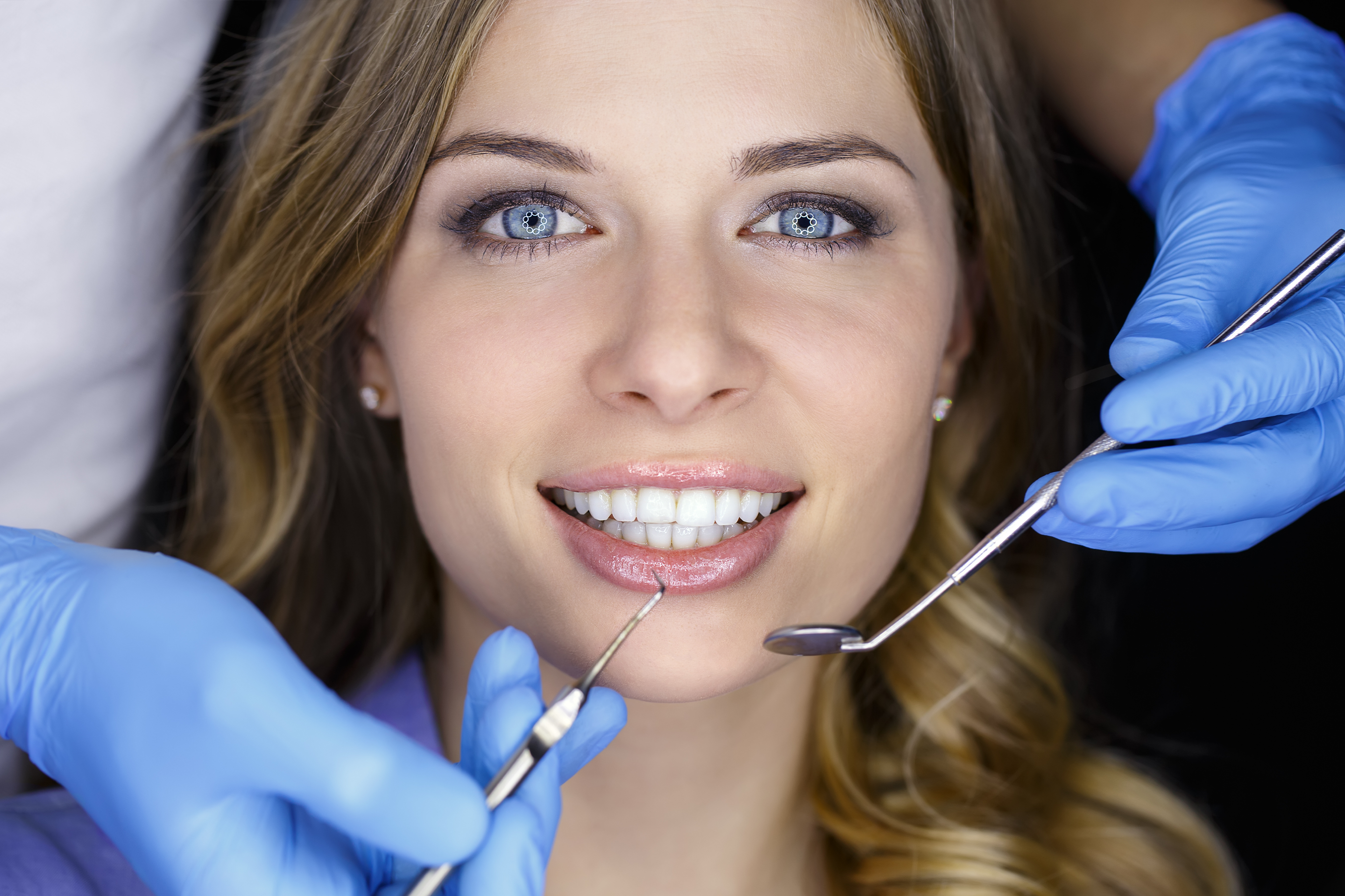 Female patient having teeth cleaned by dentist