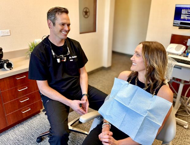 Dr. Hinkle talking to female patient in dental chair